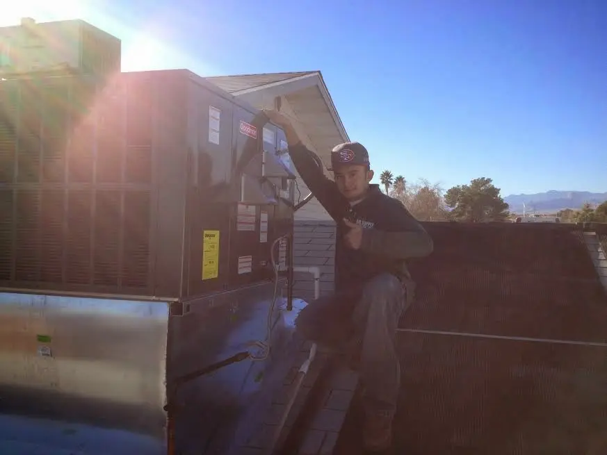HVAC technician performing AC Tune-Up on a rooftop unit in Wildomar